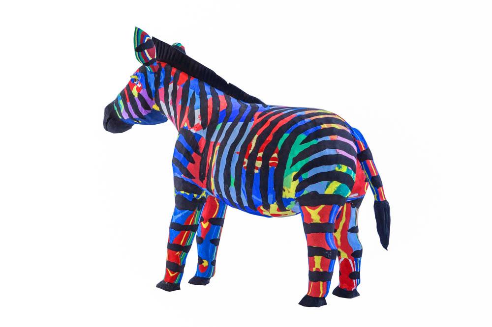 Hand-carved multicolored zebra sculpture made of upcycled flip flops by Ocean Sole.