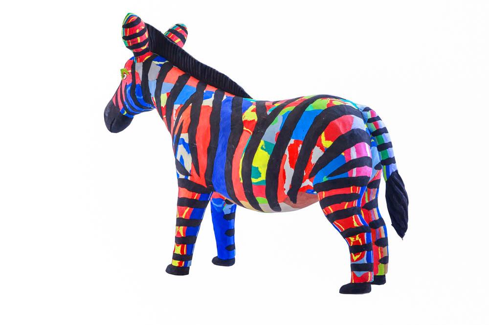 Hand-carved multicolored zebra sculpture made of upcycled flip flops by Ocean Sole.