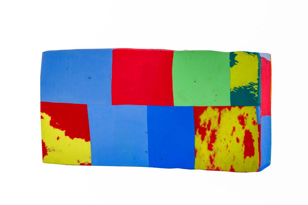 Hand-carved multicolored yoga block made of upcycled flip flops by Ocean Sole.