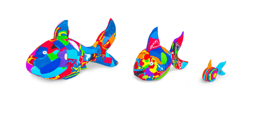 Three hand-carved multicolored reef fish sculptures made of upcycled flip flops by Ocean Sole lined up in size comparison.